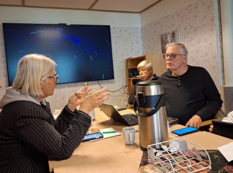Seniorer runt konferensbord, deltar i ITkafé 