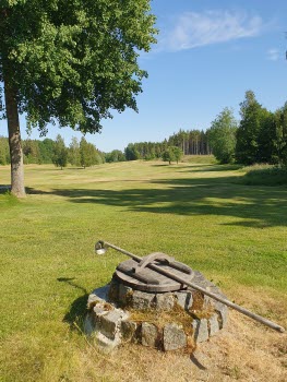 Gammal vattenbrunn på golfbanan