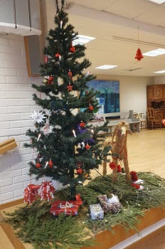 Julgran med julklappar och en julbock