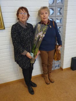 Två damer som står vid en tegelvägg