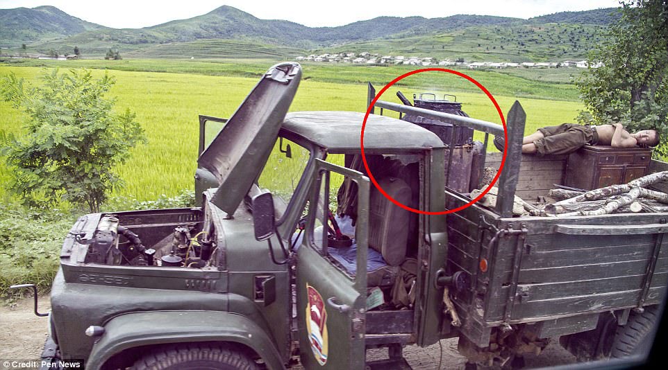 The true face of Kim Jong-un's army has been revealed in pictures smuggled out of North Korea showing ageing wood-powered trucks (pictured) and exhausted soldiers asleep on the roadside  
