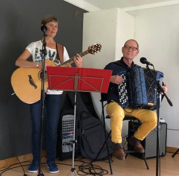 En kvinna som spelar gitarr och en man som spelar dragspel
