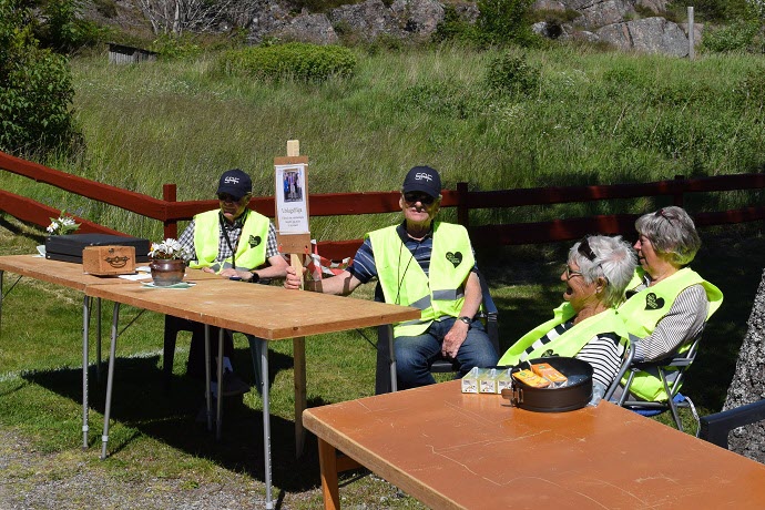 Håkan rättar, Björn håller skylten och Barbro och Inga-Lill tittar på, arbetsfördelningen i slutet av dagen. Foto: Leif