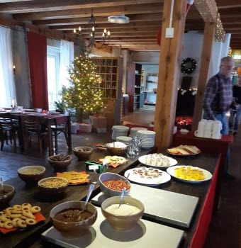 Del av julbordet,efterätter och. I bakgrunden en julgran och en gäst påväg till sitt bord godis