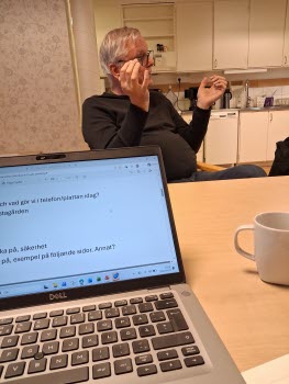 Seniorer runt konferensbord, deltar i ITkafé 