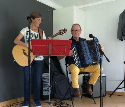 En kvinna som spelar gitarr och en man som spelar dragspel