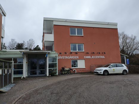 Tegelbyggnad med entré. På väggen finns skyltat Sävstagården och Familjecentral i vitt