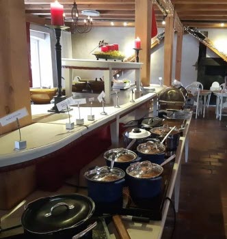 Julbord med varmrätter i en mängd olika grytor