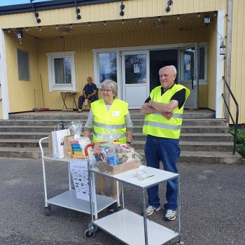 Lotterivinster utlämnas av en man och en kvinna från en vagn frmför ingången till Folkets park