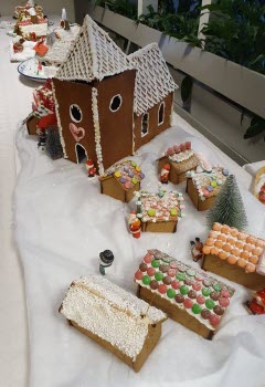 Pepparkakshus i form av en kyrka, sju små pepparkakshus framför kyrkan