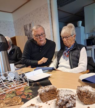 Seniorer runt konferensbord, deltar i ITkafé 