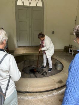 Vår guide Pia hämtar vatten från högbrunnen