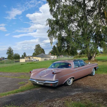 En raggarbil på parkeringen framför Folkets park. En rosa Imperial.